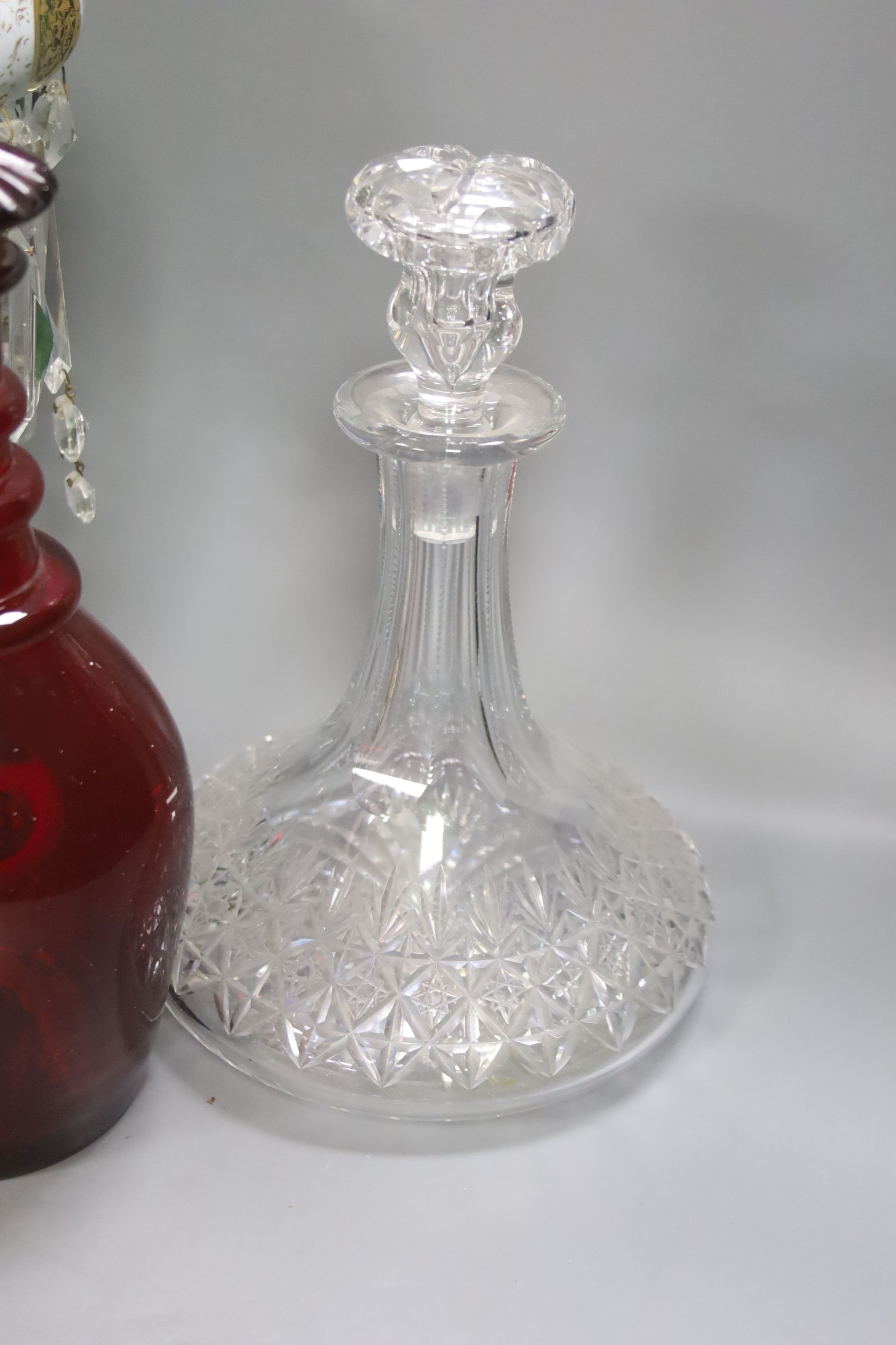 A rare ruby glass decanter circa 1830, a Bohemian overlaid glass table lustre and a cut clear glass ship's decanter, tallest 30cm